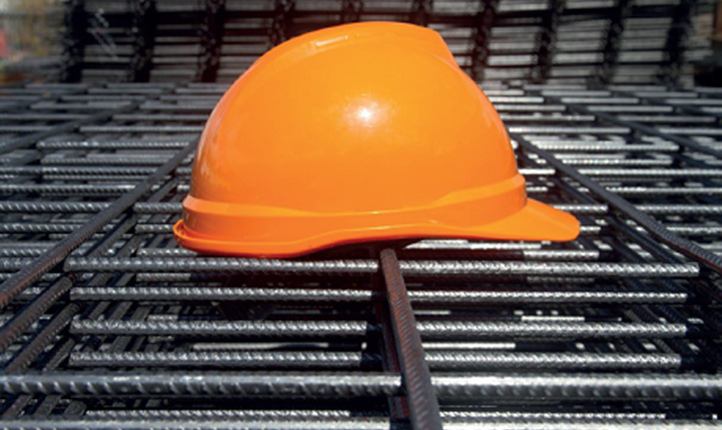  A hard hat resting on a metal grid, symbolising safety measures in industrial or construction settings.