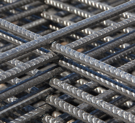 Close-up of steel bars intersecting with a metal mesh